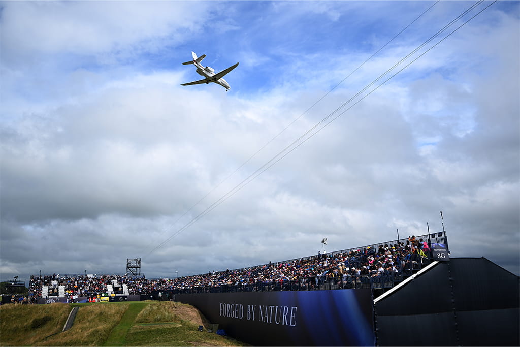 An airplane flies overhead during The Open